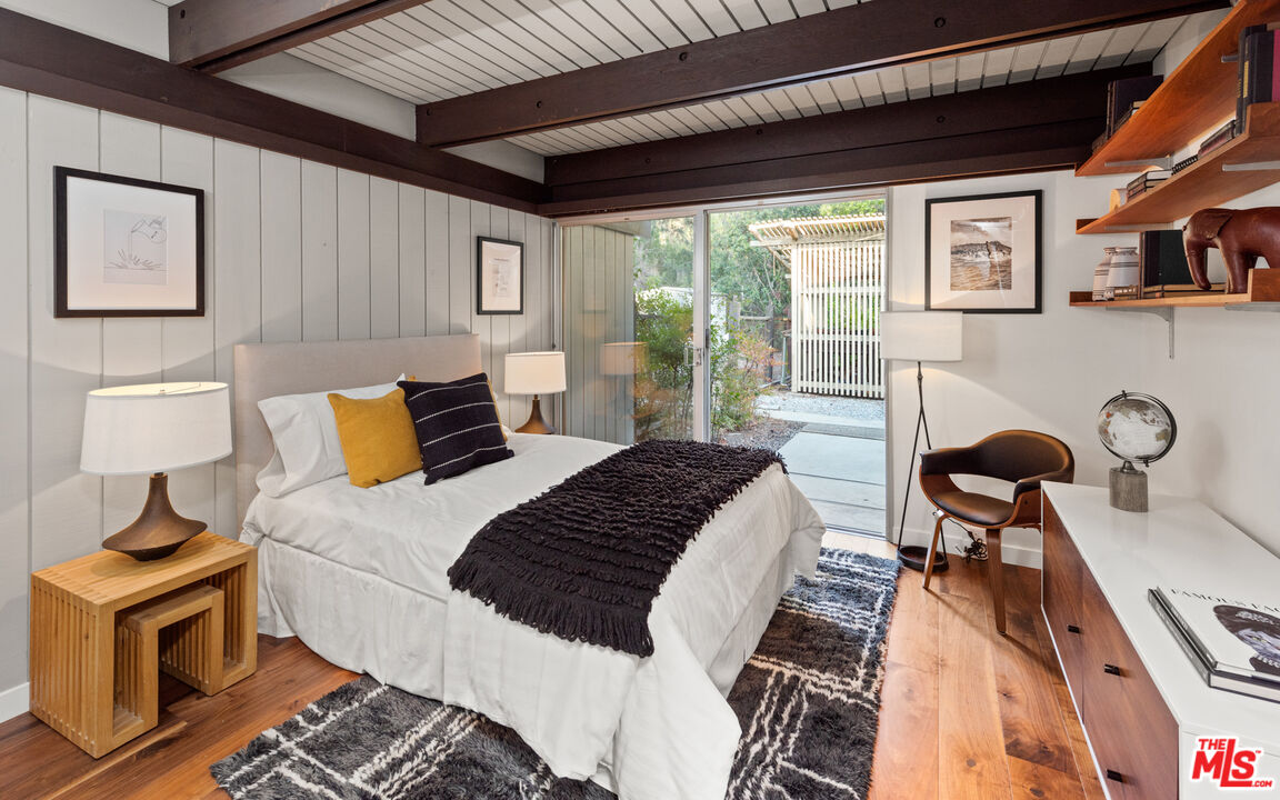 1030 Rivas Canyon Road Pacific Palisades, CA 90272 - Photo 24 of 42 a bedroom with a bed wooden floor and window