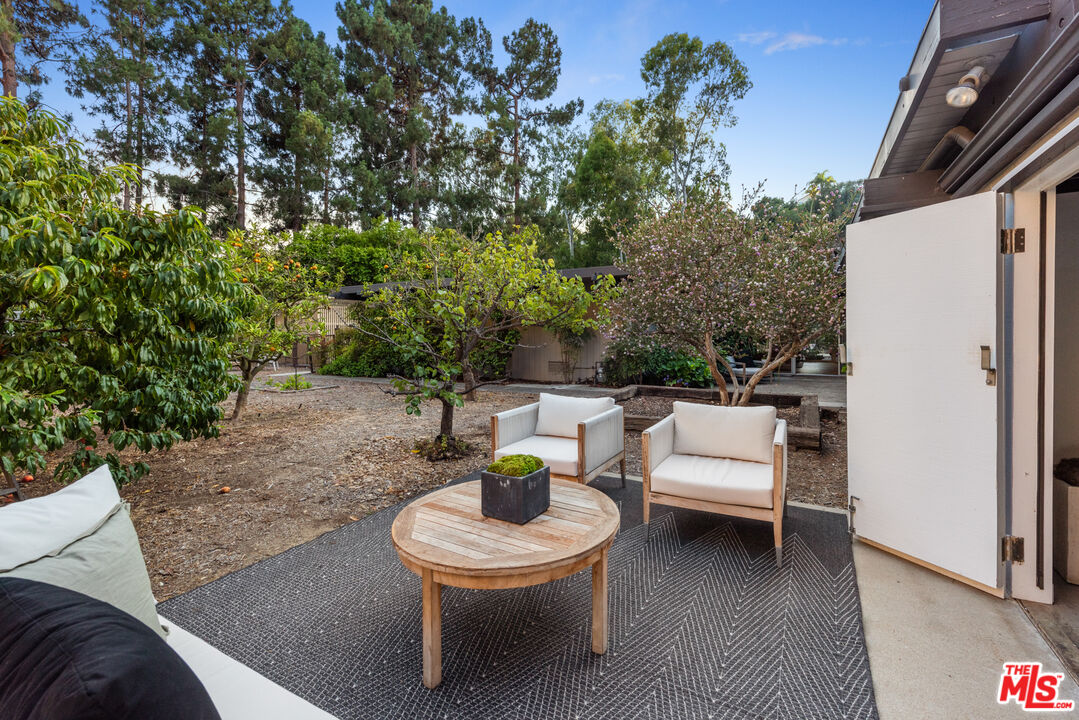 1030 Rivas Canyon Road Pacific Palisades, CA 90272 - Photo 27 of 42 a view of a patio with a table and chairs and a fire pit