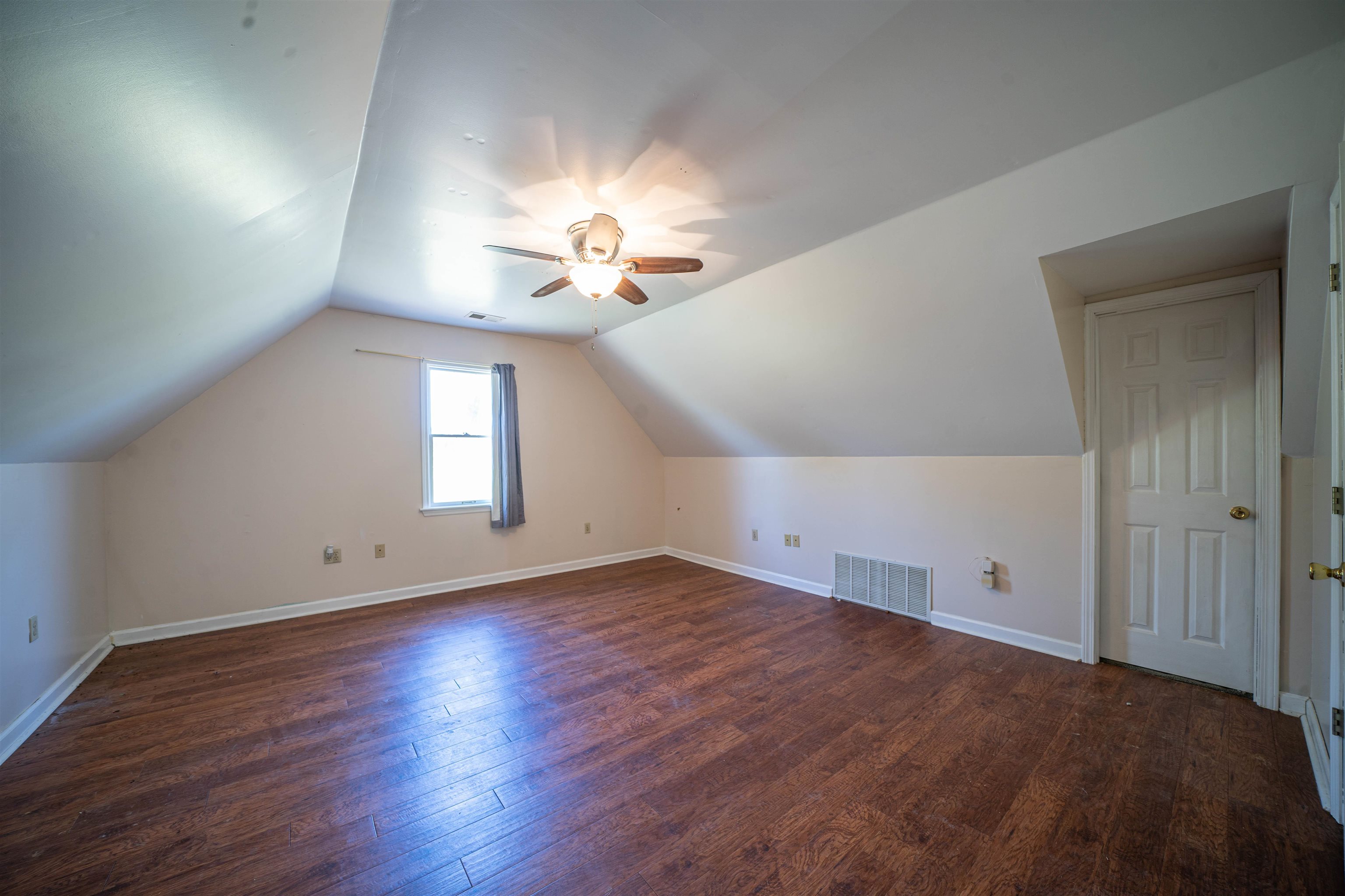 345 Allen Road Williston, TN 38076 - Photo 9 of 25 an empty room with wooden floor chandelier fan and windows