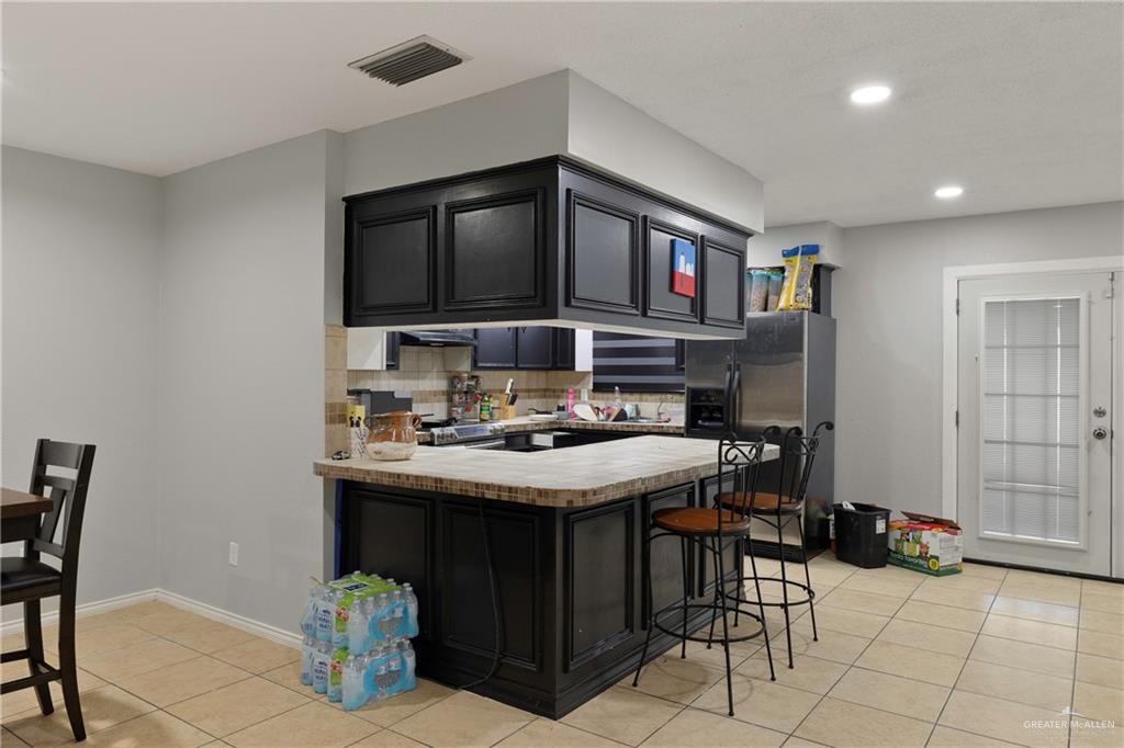 4407 North Raul Longoria Road San Juan, TX 78589 - Photo 7 of 22 a kitchen with a stove a sink and a refrigerator