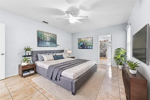 a spacious bedroom with a large bed and a chandelier