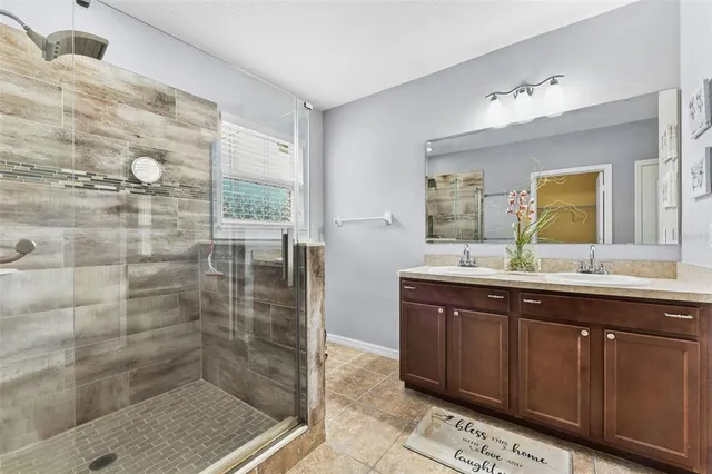 a bathroom with a granite countertop sink a mirror and a shower
