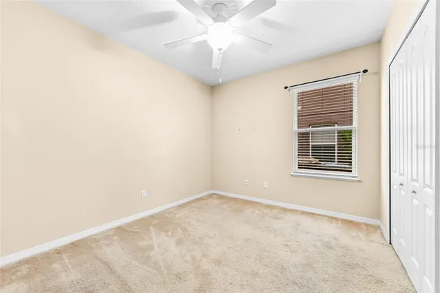 a bedroom with a bed a window and a flat screen tv