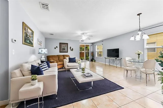 a living room with furniture a flat screen tv and kitchen view