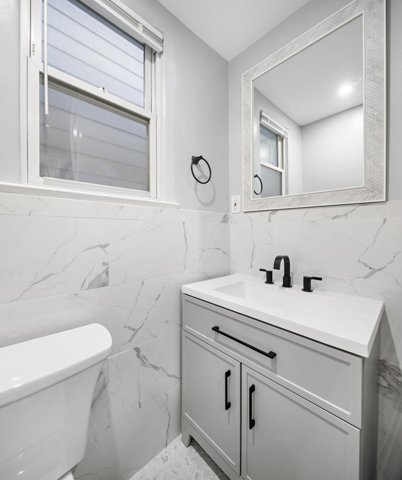 197 Hutton Street, Unit 1 Jersey City, NJ 07307 - Photo 13 of 15 a bathroom with a sink toilet and a mirror
