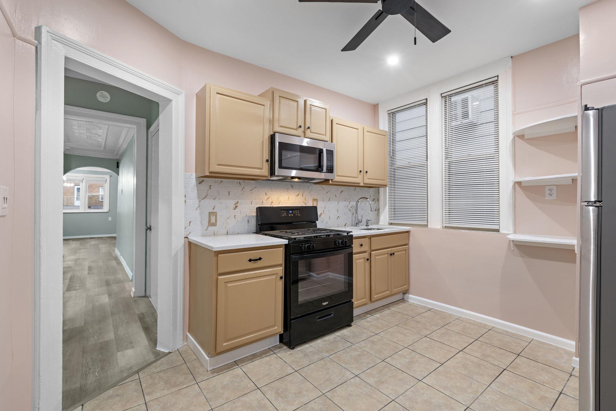 197 Hutton Street, Unit 1 Jersey City, NJ 07307 - Photo 6 of 15 a kitchen with stainless steel appliances granite countertop a stove a sink and a refrigerator