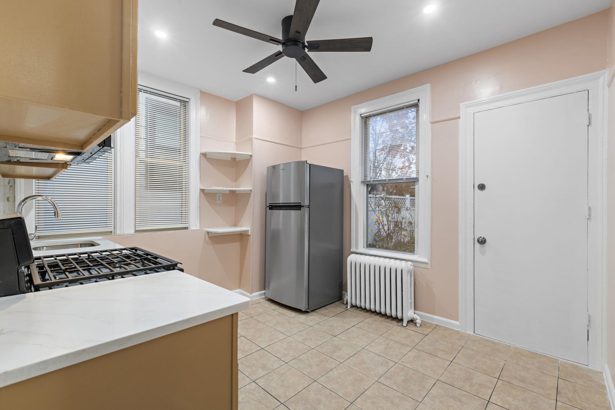 197 Hutton Street, Unit 1 Jersey City, NJ 07307 - Photo 7 of 15 a kitchen with stainless steel appliances a refrigerator and a stove top oven
