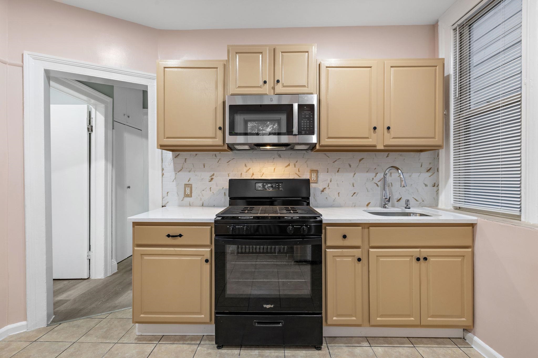 197 Hutton Street, Unit 1 Jersey City, NJ 07307 - Photo 8 of 15 a kitchen with white cabinets and appliances
