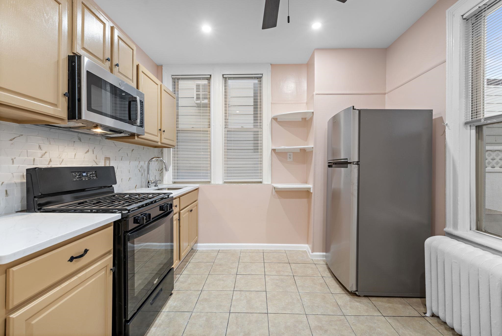 197 Hutton Street, Unit 1 Jersey City, NJ 07307 - Photo 9 of 15 a kitchen with stainless steel appliances granite countertop a refrigerator stove and microwave