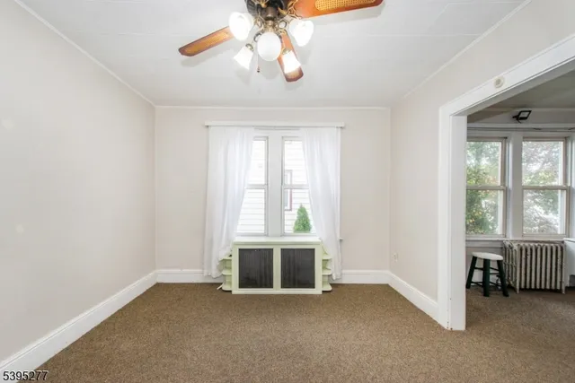 an empty room with closet and a chandelier fan