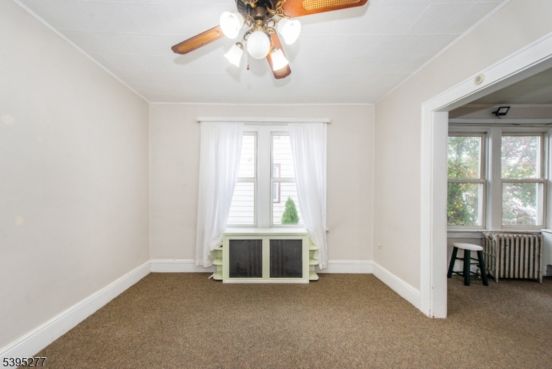 16 Willet Street Bloomfield, NJ 07003 - Photo 7 of 19 an empty room with chandelier fan and windows