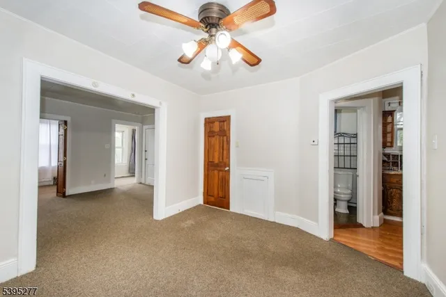 an empty room with windows and ceiling fan
