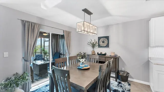 a view of a dining room and livingroom with furniture wooden floor a chandelier