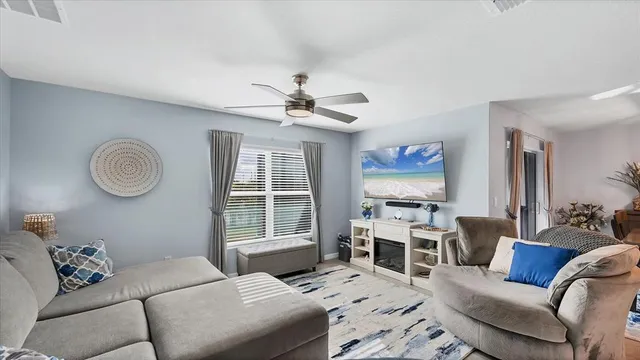 a living room with furniture ceiling fan and a window
