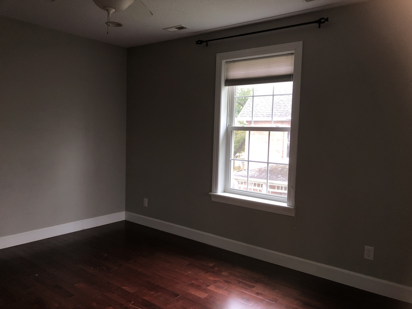 321 North Quincy Street Clinton, IL 61727 - Photo 8 of 12 a view of an empty room with wooden floor and a window