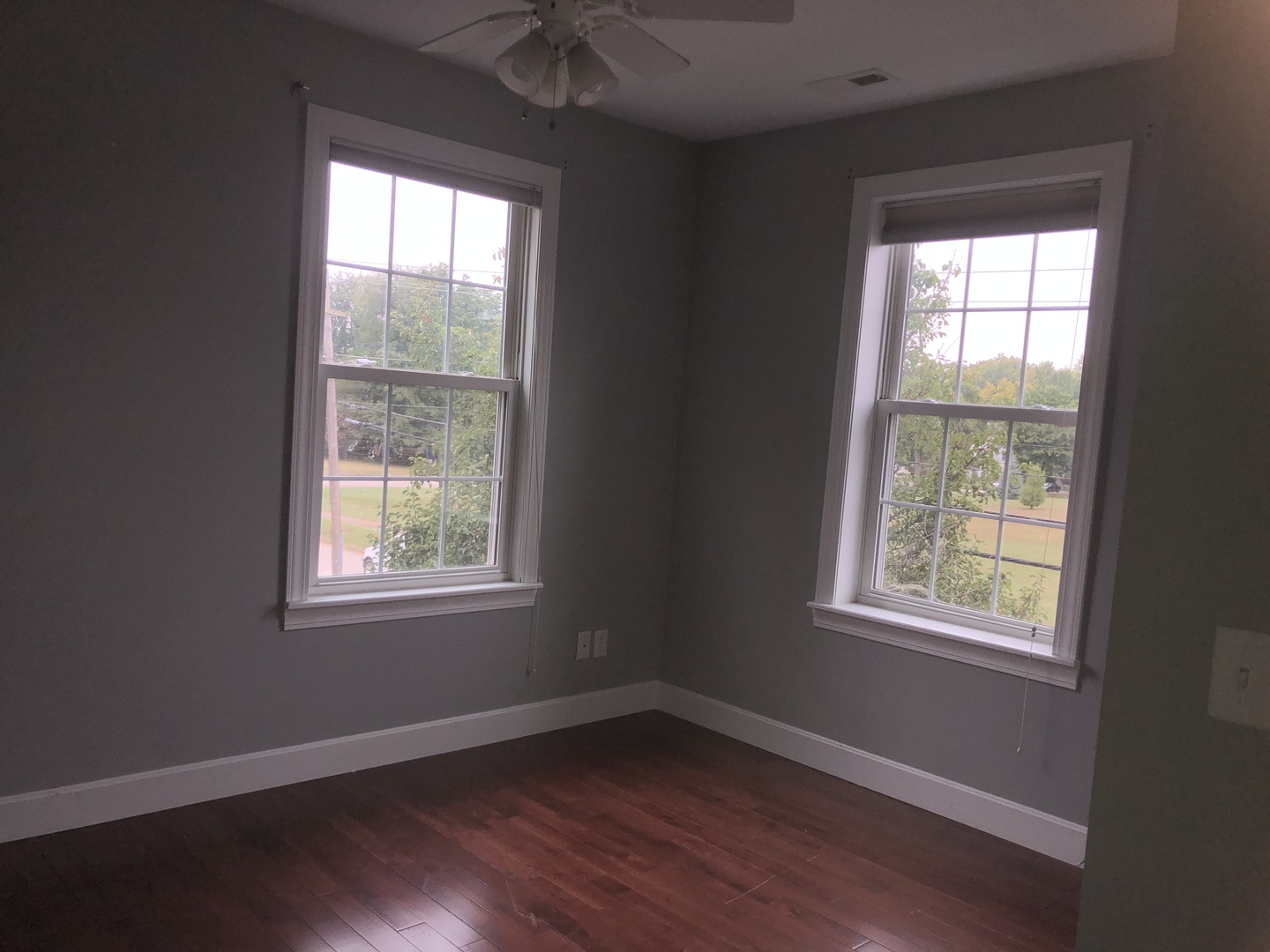 321 North Quincy Street Clinton, IL 61727 - Photo 10 of 12 a view of an empty room with wooden floor and a window