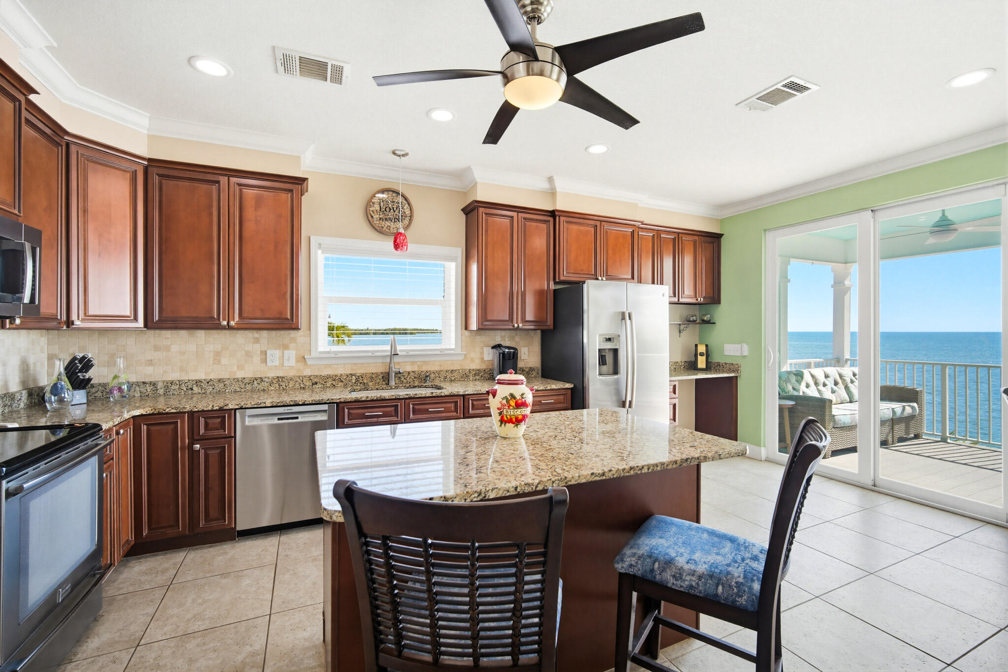 183 Star Lane Key West, FL 33040 - Photo 22 of 70 a kitchen with stainless steel appliances granite countertop a stove a sink dishwasher and a refrigerator with wooden cabinets
