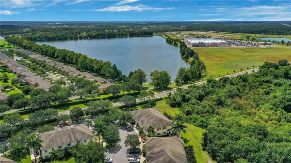 an aerial view of a residential houses with outdoor space and lake view