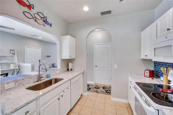 a kitchen with granite countertop a sink stainless steel appliances and cabinets