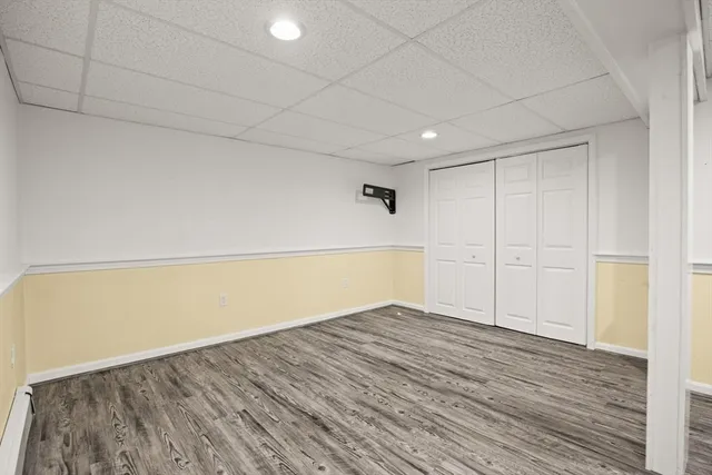 an empty room with a cabinet and a refrigerator