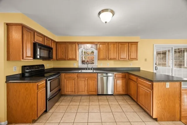 a kitchen with stainless steel appliances granite countertop a stove top oven a sink dishwasher and a microwave oven on the blue kitchen countertops