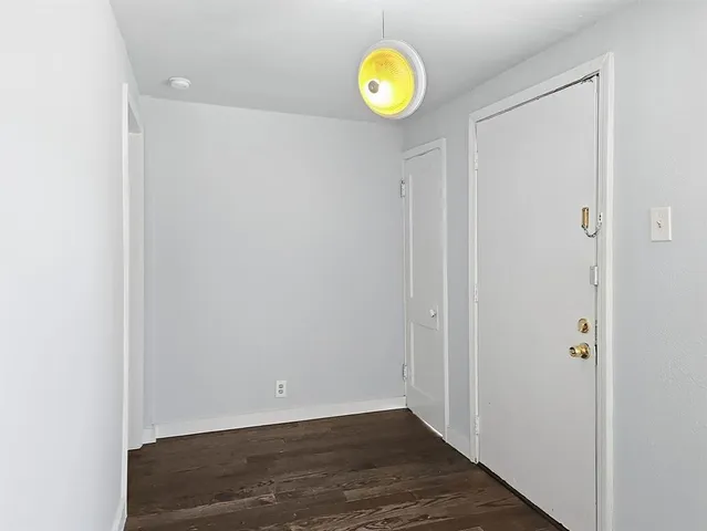a kitchen with a refrigerator stove and wooden floor
