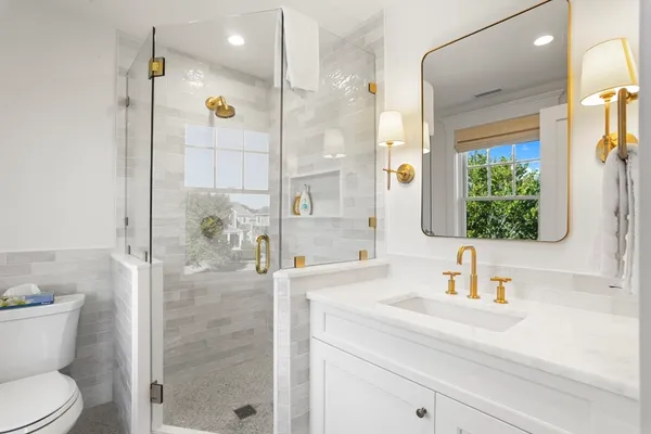 a bathroom with a sink a toilet and shower