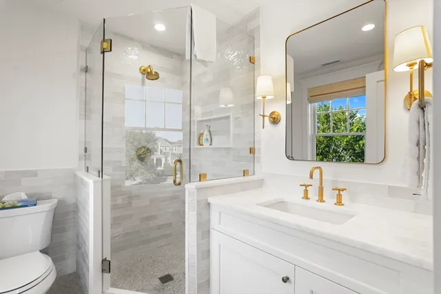 a bathroom with a sink a toilet and shower