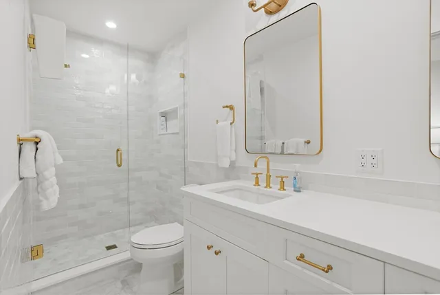 a bathroom with a sink a toilet and shower