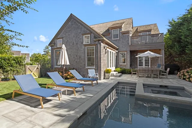a view of a house with backyard and sitting area