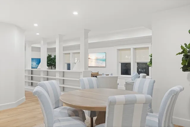 a living room with furniture and a large mirror next to a window