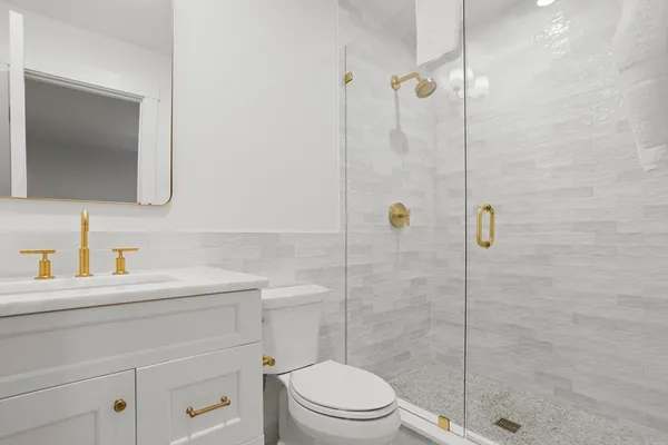 a bathroom with a sink a toilet and shower
