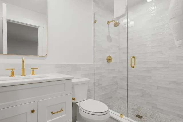 a bathroom with a sink a toilet and shower