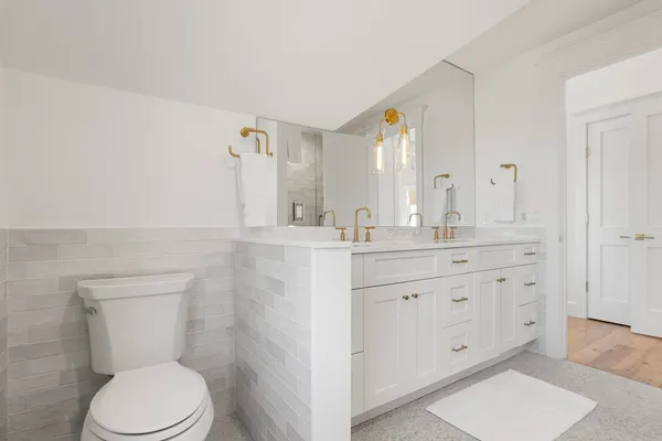 a bathroom with a granite countertop toilet sink and mirror