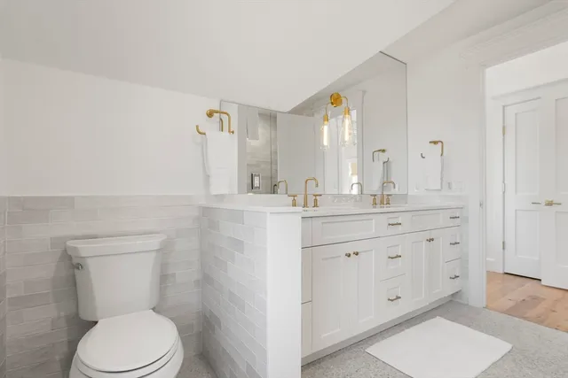 a bathroom with a granite countertop toilet sink and mirror