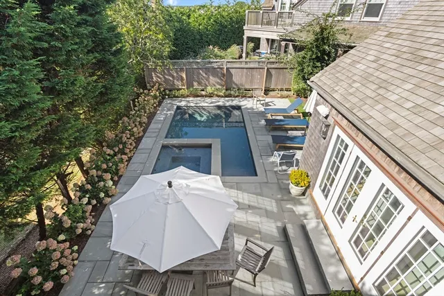 a view of a patio with table and chairs with wooden floor and fence