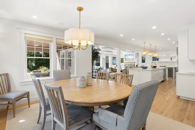 a dining room with furniture a chandelier and wooden floor