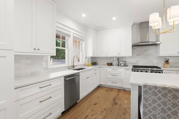 a kitchen with granite countertop white cabinets and white appliances