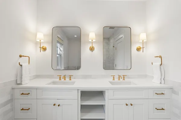 a bathroom with double vanity sinks and a mirror