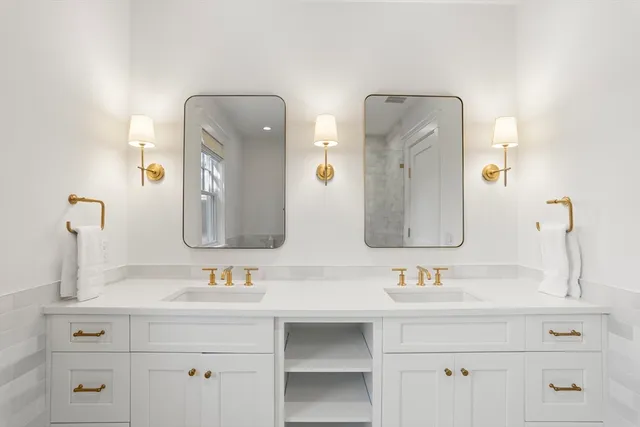 a bathroom with double vanity sinks and a mirror