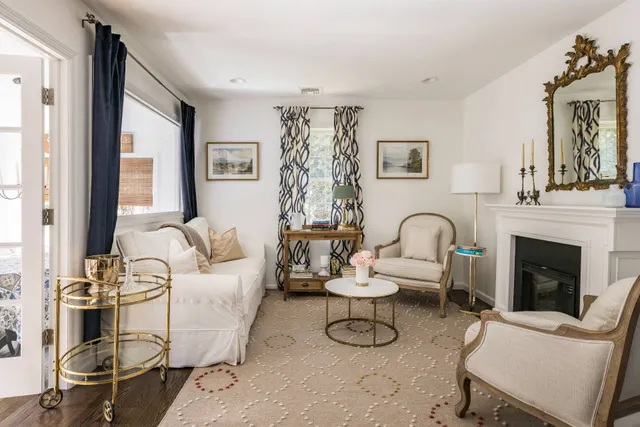 a living room with furniture a fireplace and a large window
