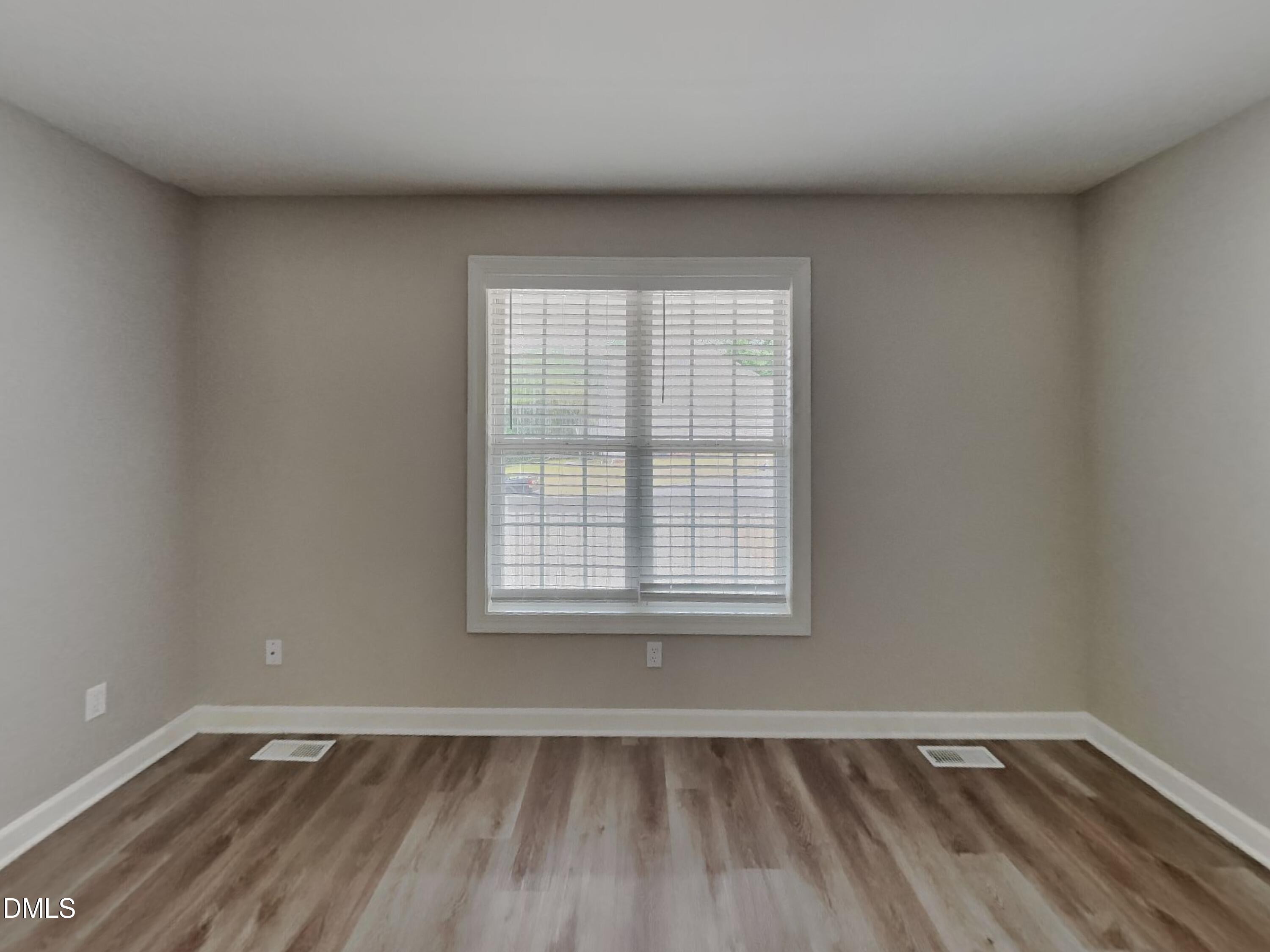 3224 Cotton Grove Raleigh, NC 27610 - Photo 7 of 15 an empty room with wooden floor and windows