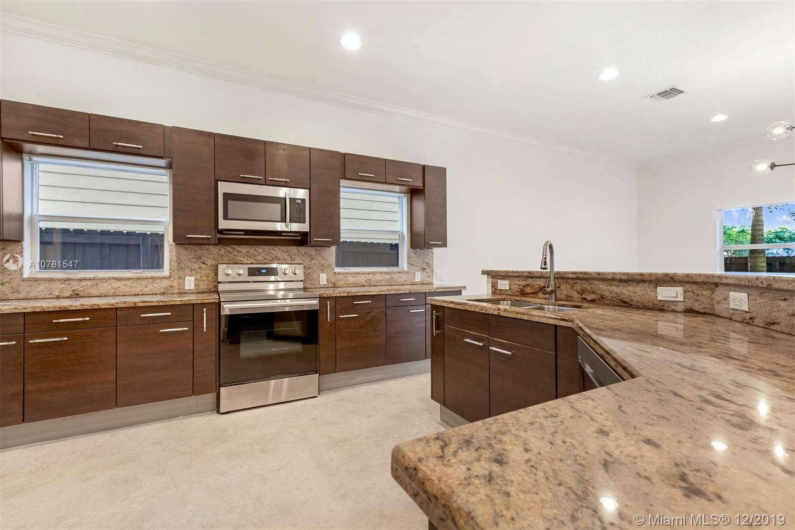 a kitchen with stainless steel appliances kitchen island granite countertop a sink stove and oven