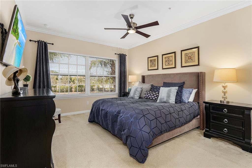 23550 Alamanda Drive, Unit 202 Estero, FL 34135 - Photo 15 of 26 a bedroom with a bed a window and a flat screen television