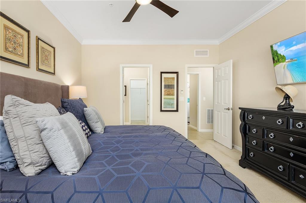 23550 Alamanda Drive, Unit 202 Estero, FL 34135 - Photo 16 of 26 a bedroom with a bed and a night stand