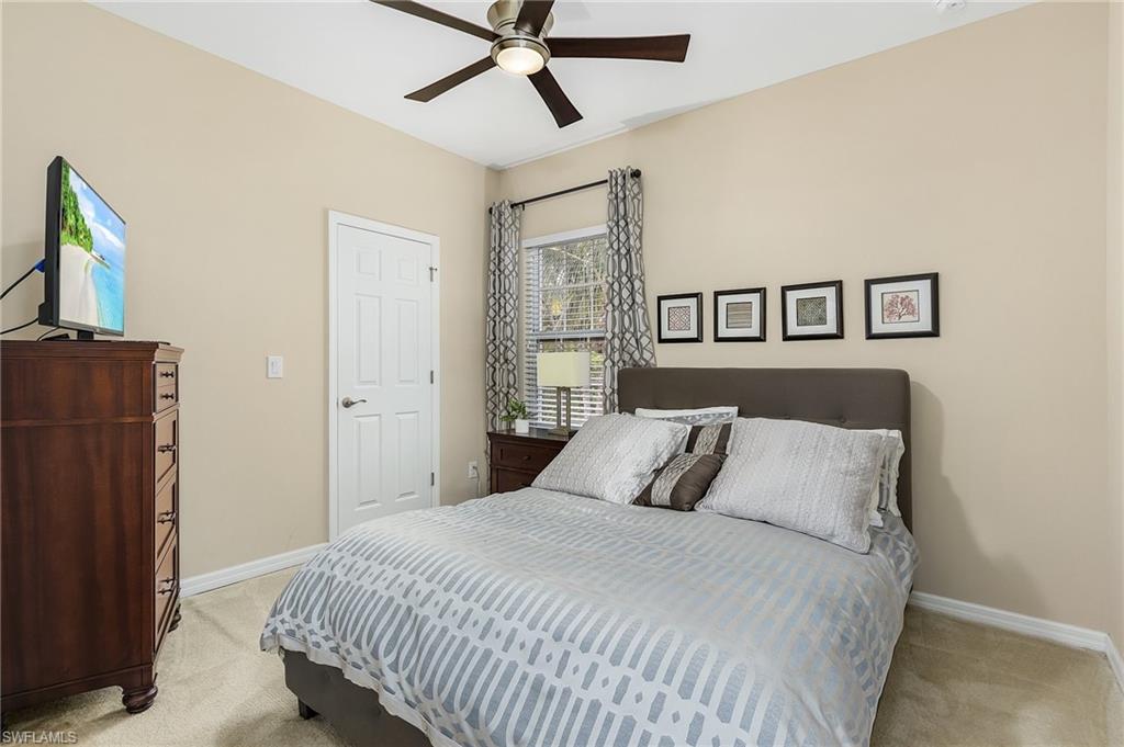 23550 Alamanda Drive, Unit 202 Estero, FL 34135 - Photo 19 of 26 a bedroom with a bed and painting on the wall