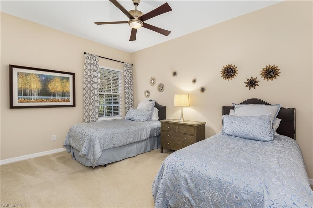 23550 Alamanda Drive, Unit 202 Estero, FL 34135 - Photo 20 of 26 a bedroom with a large bed and a chandelier