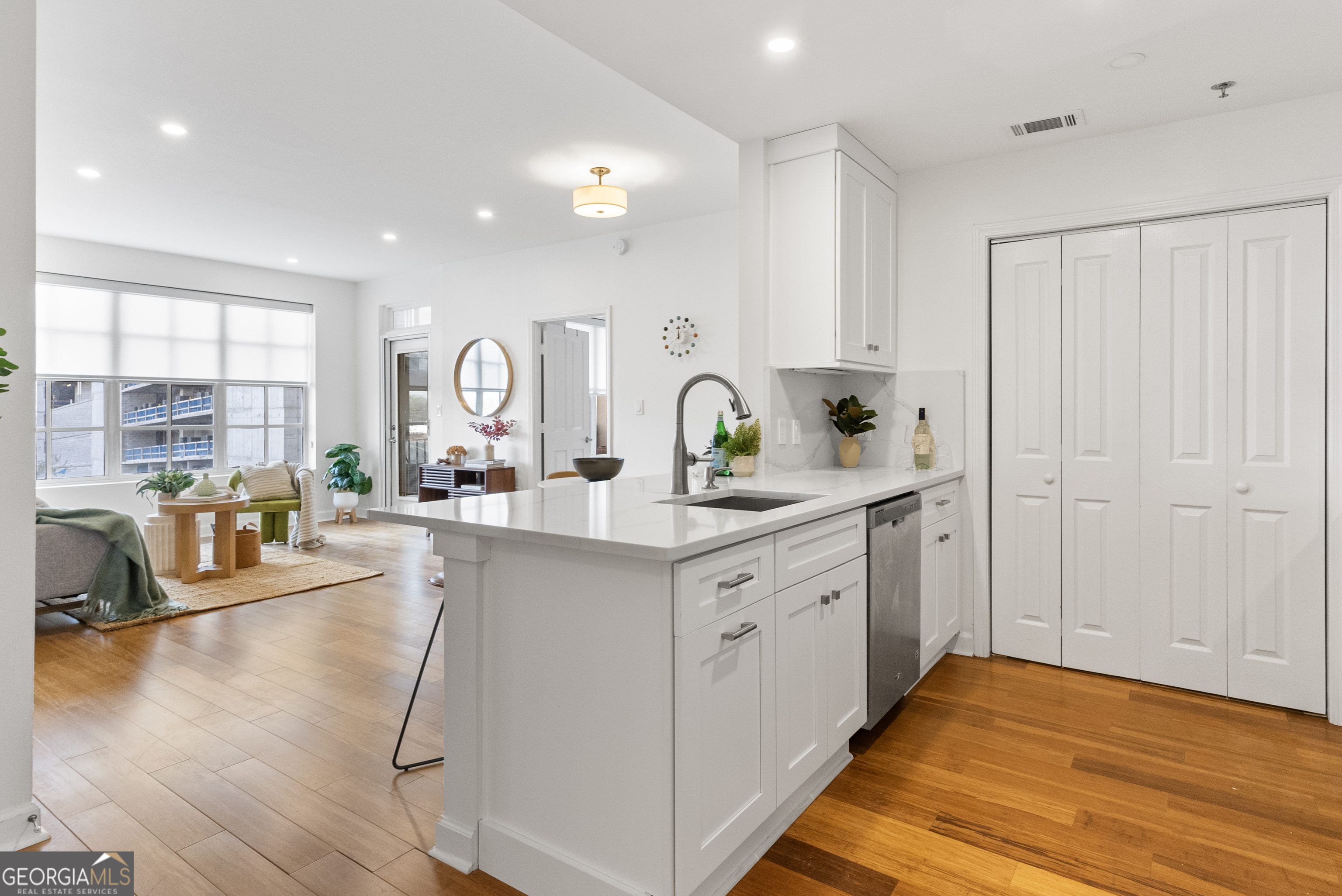 a large kitchen with kitchen island white cabinets and stainless steel appliances