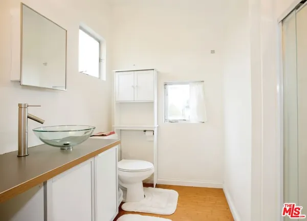 a bathroom with a granite countertop sink toilet and a mirror