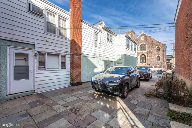 a backyard of a house with barbeque oven table and chairs